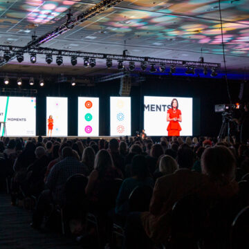 Event-Photography Coldea Productions captures an inspiring presentation at the Modere 20/20 Vision conference at Anaheim Convention Center, with a speaker on stage engaging an attentive audience