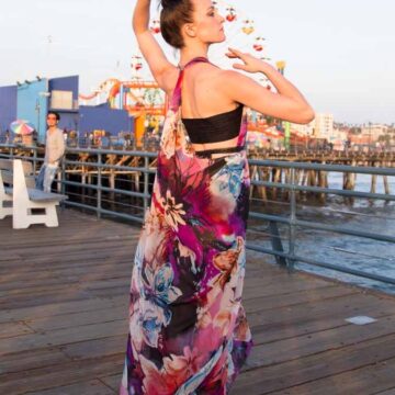 Ballet dancer in a floral dress performing gracefully on Santa Monica boardwalk, blending fashion and dance, captured by Coldea Productions.