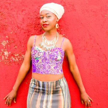 Fashion and portrait photography captured by Coldea Productions, featuring a model posed against a colorful mural, emphasizing style and urban art in an engaging setting