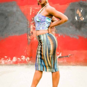 Stylish portrait of a woman in vibrant attire posing against an urban mural, showcasing Coldea Productions' expertise in portrait photography.