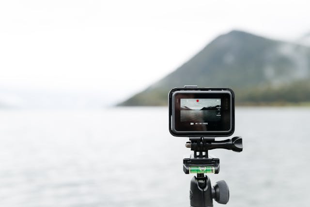 Action camera capturing a scenic lake view with mountains in the background, symbolizing outdoor videography.