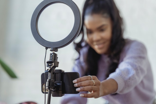 A happy woman setting up her smartphone to record a video.