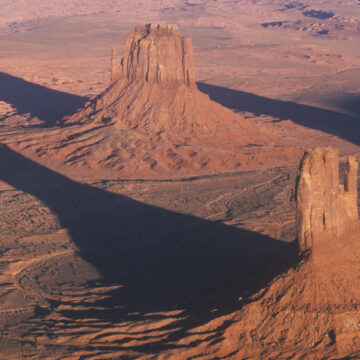 Aerial view of Monument Valley rock formations casting long shadows, captured by Coldea Productions’ drone and aerial photography services