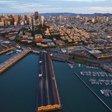 Aerial view of San Francisco’s waterfront and cityscape during sunset, showcasing Coldea Productions' drone photography expertise