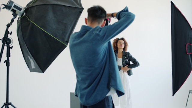 Photographer taking a professional portrait in a studio setup.