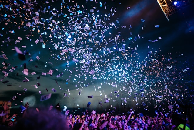 Crowd enjoying a lively event in Los Angeles with confetti falling under colorful stage lights