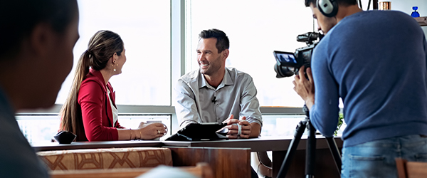 Professional video crew filming a corporate interview in an office setting, ideal for corporate video presentation services by Coldea Productions.