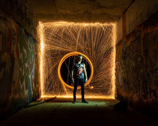 Man standing in front of a fire ring.