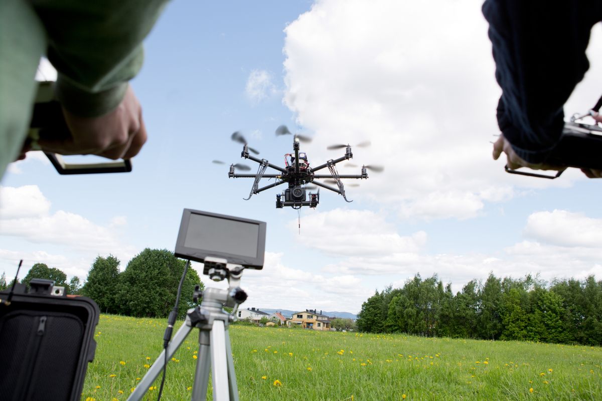Operators flying a professional drone equipped with a camera for aerial photography.