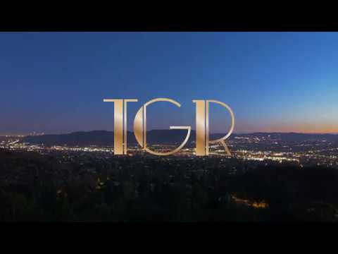 Nighttime view of a cityscape with "TGR" in elegant gold lettering, featured in a restaurant video presentation by Coldea Productions.
