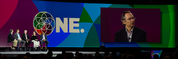 Conference panel discussion and keynote speaker featured on a large screen during an event in Long Beach, photographed by Coldea Productions.