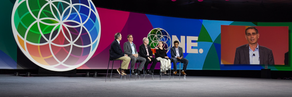 Panel discussion with vibrant "ONE" backdrop and large screen display, ideal for event photography in Riverside, California, by Coldea Productions.