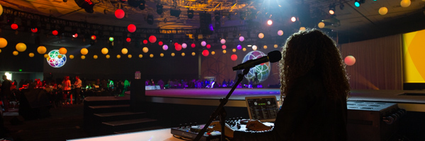 A DJ performing at a vibrant event with colorful lighting and decorations, showcasing dynamic moments captured in event photography by Coldea Productions