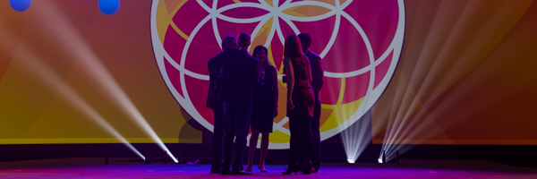 Group of professionals on a lit stage with vibrant lighting, captured by Coldea Productions event photography services in Los Angeles