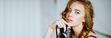 Portrait of a woman holding a camera, showcasing Coldea Productions' professional headshots photography services nationwide.