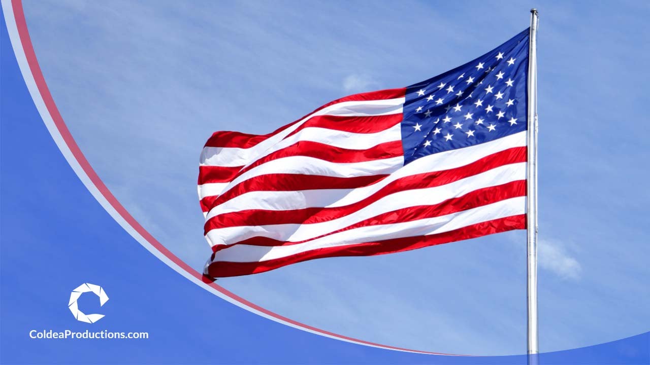 American flag waving against a blue sky, representing national pride, captured by Coldea Productions.