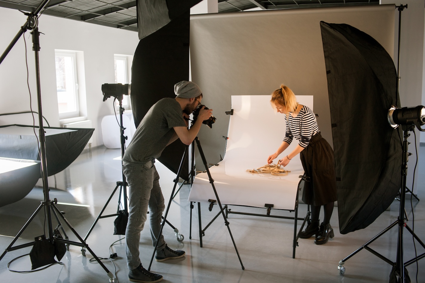 Photographer and stylist working together in a studio setting to capture a product demonstration.