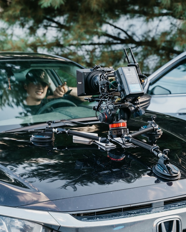 Cinematic camera rig mounted on a luxury car hood during Coldea Productions automotive video shoot capturing dynamic driving scenes.