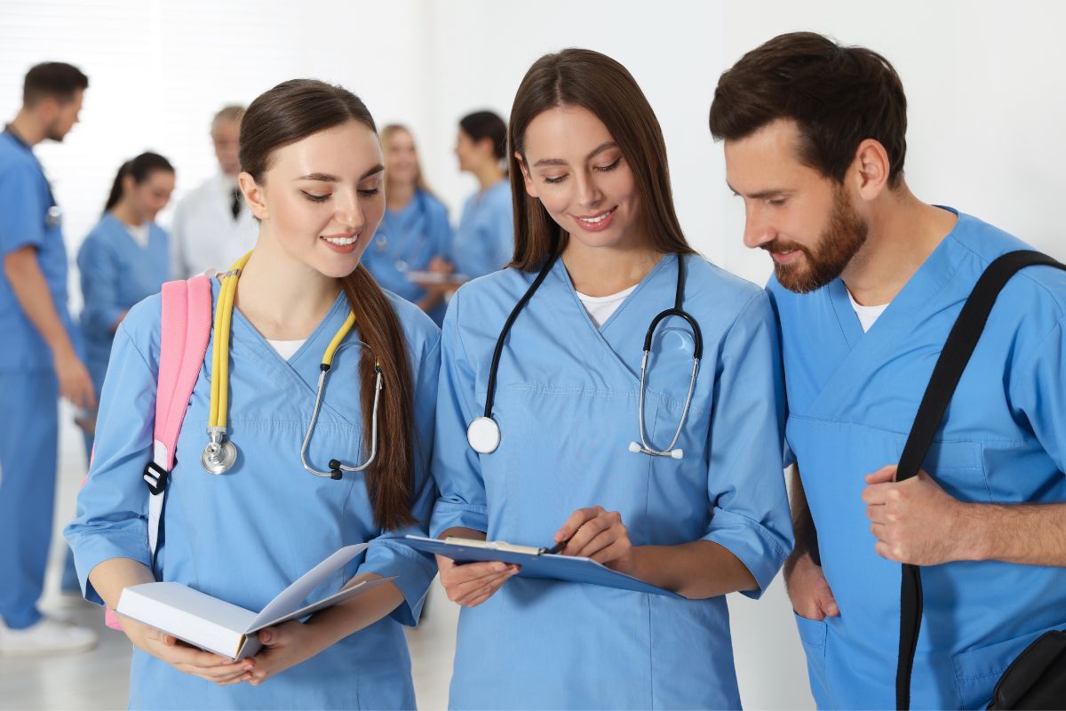 Group of medical professionals in blue scrubs discussing patient care, symbolizing teamwork and professionalism in healthcare.