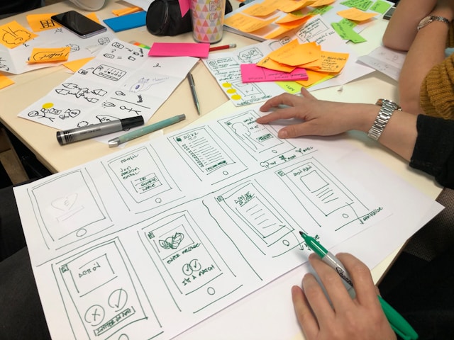 Creative team designing storyboards and visual concepts with sketches and sticky notes during a brainstorming session.