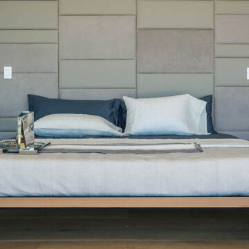 Modern bedroom with stylish decor, featuring a minimalist bed and neutral color palette, showcasing real estate photography by Coldea Productions.