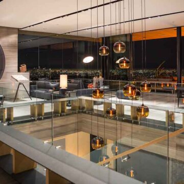 Luxurious modern living space with floor-to-ceiling windows and ambient lighting, showcasing city views at night, photographed by Coldea Productions for real estate.