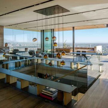 Luxury modern interior with panoramic city views, circular window, and stylish lighting, photographed by Coldea Productions.