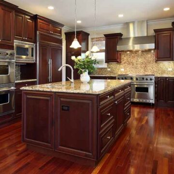 A luxurious kitchen with dark wood cabinetry and granite countertops, captured to showcase real estate photography services by Coldea Productions.