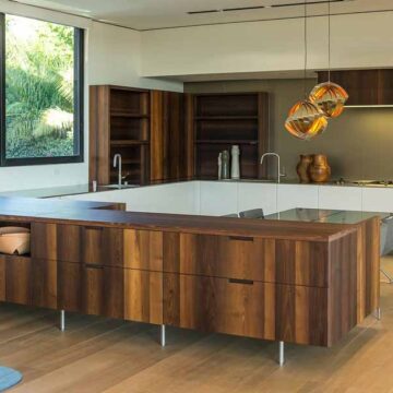 Modern kitchen with wooden cabinetry, sleek design, and stylish lighting, captured by Coldea Productions for real estate marketing.