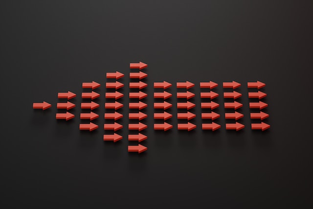 Red arrows forming a pattern on a black background, symbolizing direction and trends.