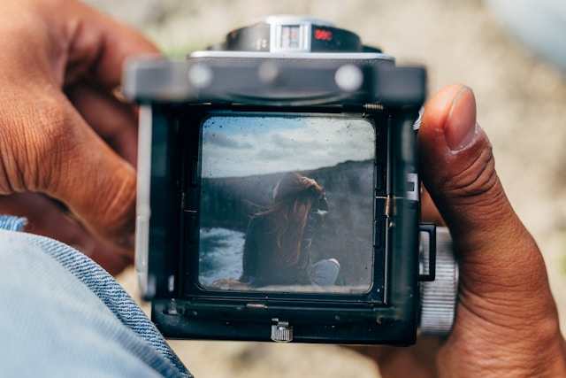 Close-up of a person capturing a scene through a vintage medium format camera photo of woman, symbolizing the art of storytelling in video marketing.