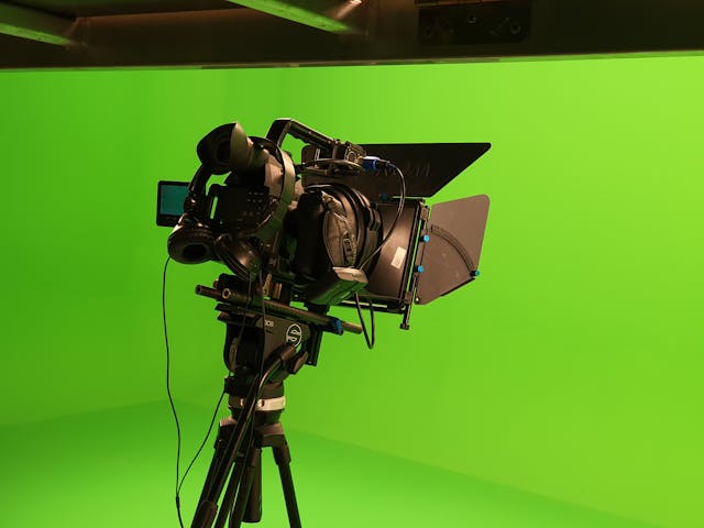 A professional camera in front of a green screen.