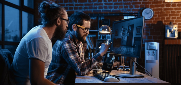 Two designers collaborating on a video animation project at a workstation.