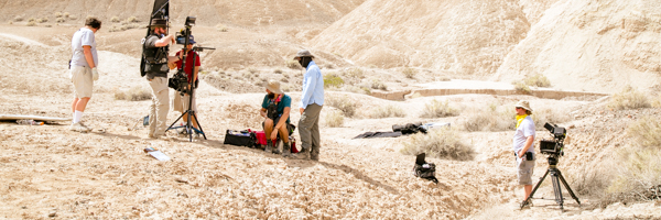 Film crew setting up equipment in a desert landscape, part of Coldea Productions' video production services in Rancho Cucamonga, California