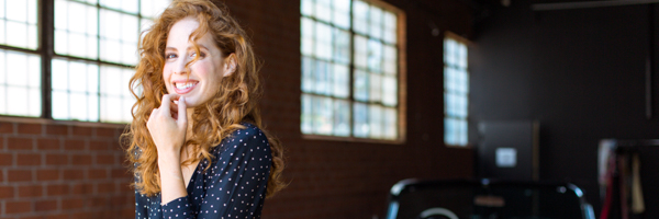 Smiling woman in a natural light studio setting, featured in Coldea Productions' video production showcase in San Diego, California