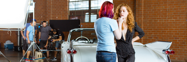 Production team preparing a model for a video commercial shoot with a classic car, part of Coldea Productions' video commercial services in Los Angeles, California
