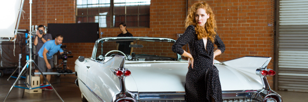 Coldea Productions crew filming a stylish commercial with a model and classic convertible on set in Anaheim, California.