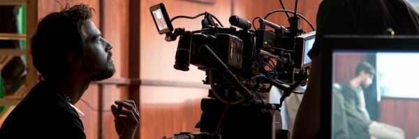 Cinematographer at work, adjusting a professional camera setup during a commercial video shoot.