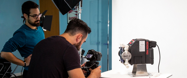 Alexis Mendez and Alex Stoica from Coldea Productions filming a Blue-White Peristaltic Metering Pump in a studio setup.