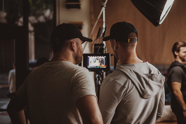 Two videographers reviewing footage on a monitor during a video shoot, symbolizing teamwork and attention to detail in video production.