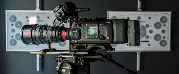 Close-up of a high-end Canon video camera on a tripod, ready for a professional shoot.