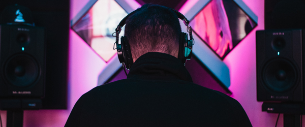Audio technician wearing headphones in a recording studio, ideal for video production services for production companies in Arizona, by Coldea Productions.