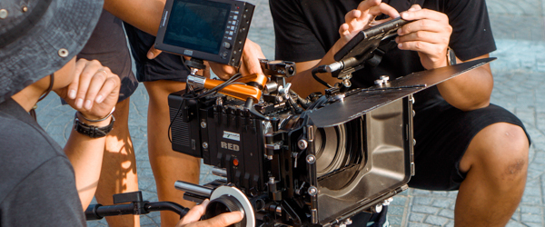Film crew adjusting a RED camera setup during an outdoor shoot, ideal for video production services for production companies in Arizona, by Coldea Productions.