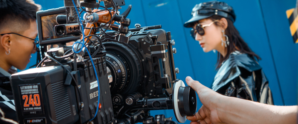 Close-up of a professional camera setup filming a model in a leather outfit, showcasing Coldea Productions' video production services